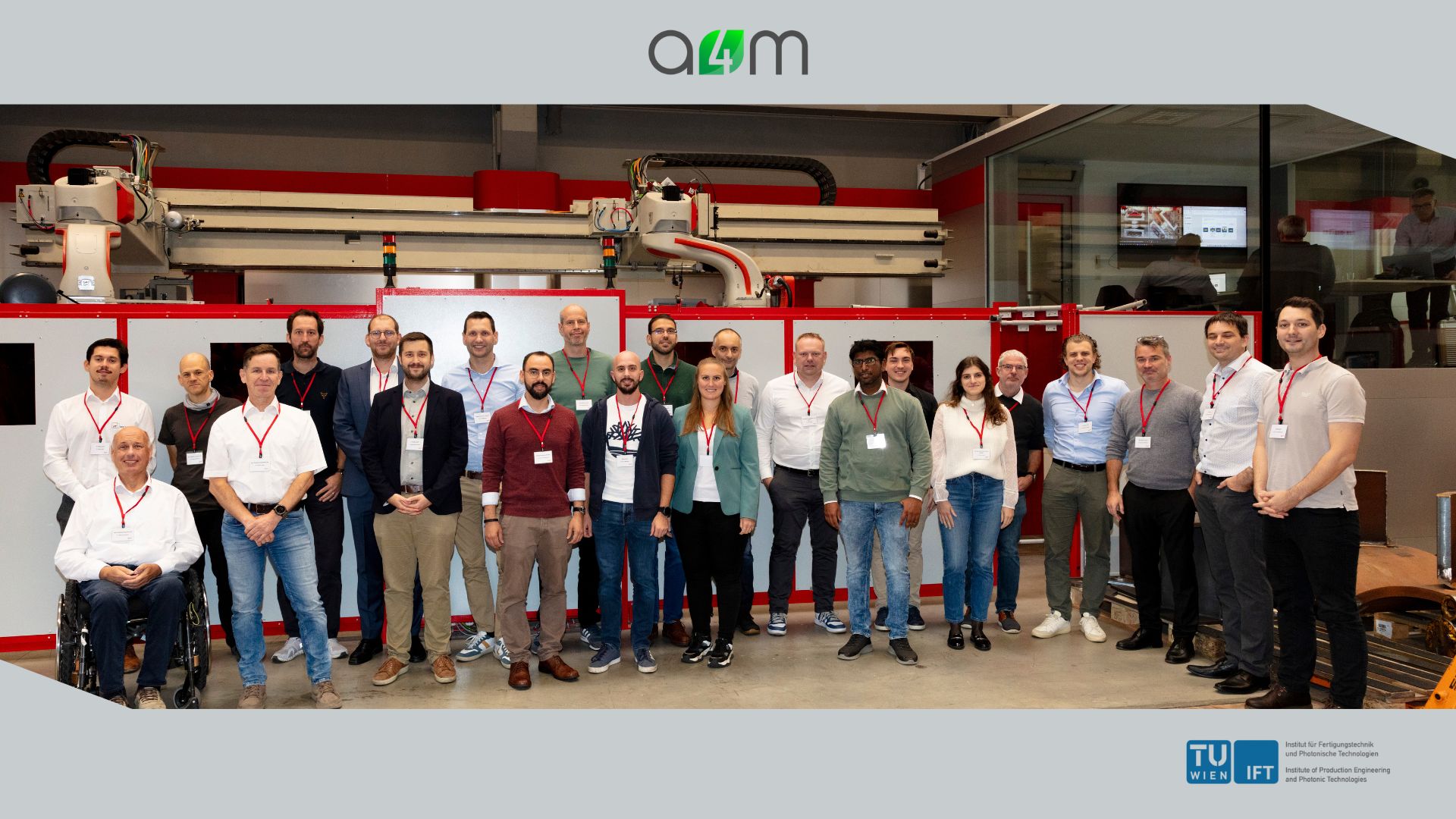 Gruppenfoto der Teilnehmenden des A4M-Konsortialtreffens bei igm Robotersysteme AG in Wiener Neudorf vor einer industriellen Fertigungsanlage.